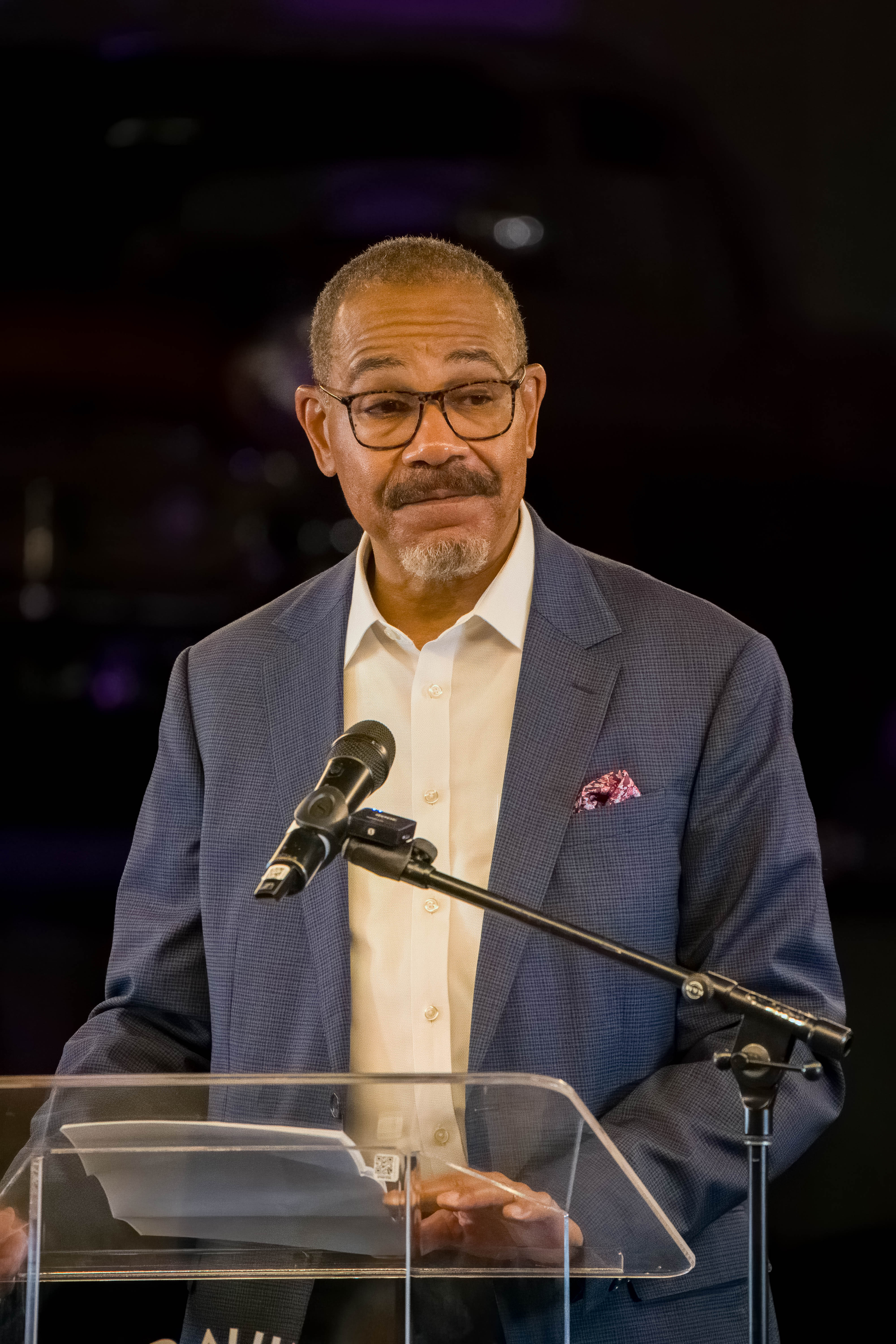 Conference attendee networking — young professional in navy blazer with event lanyard, candid moment